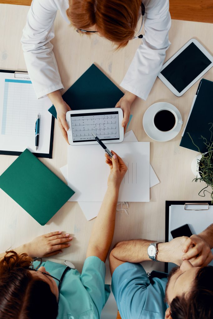 Top view of medical office staff meeting at a table